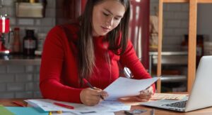 mujer jefa RRHH trabaja con documentación confirma proyecto sostiene papel- gafas-manos posa concepto de carrera